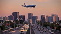 Jet aircraft on landing approach flying low over city freeway. Jet aircraft on landing approach flying low over city freeway.