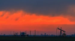 Oilfield with oil pumps and oil rigs profiled on sunset sky. Oilfield with oil pumps and oil rigs profiled on sunset sky.