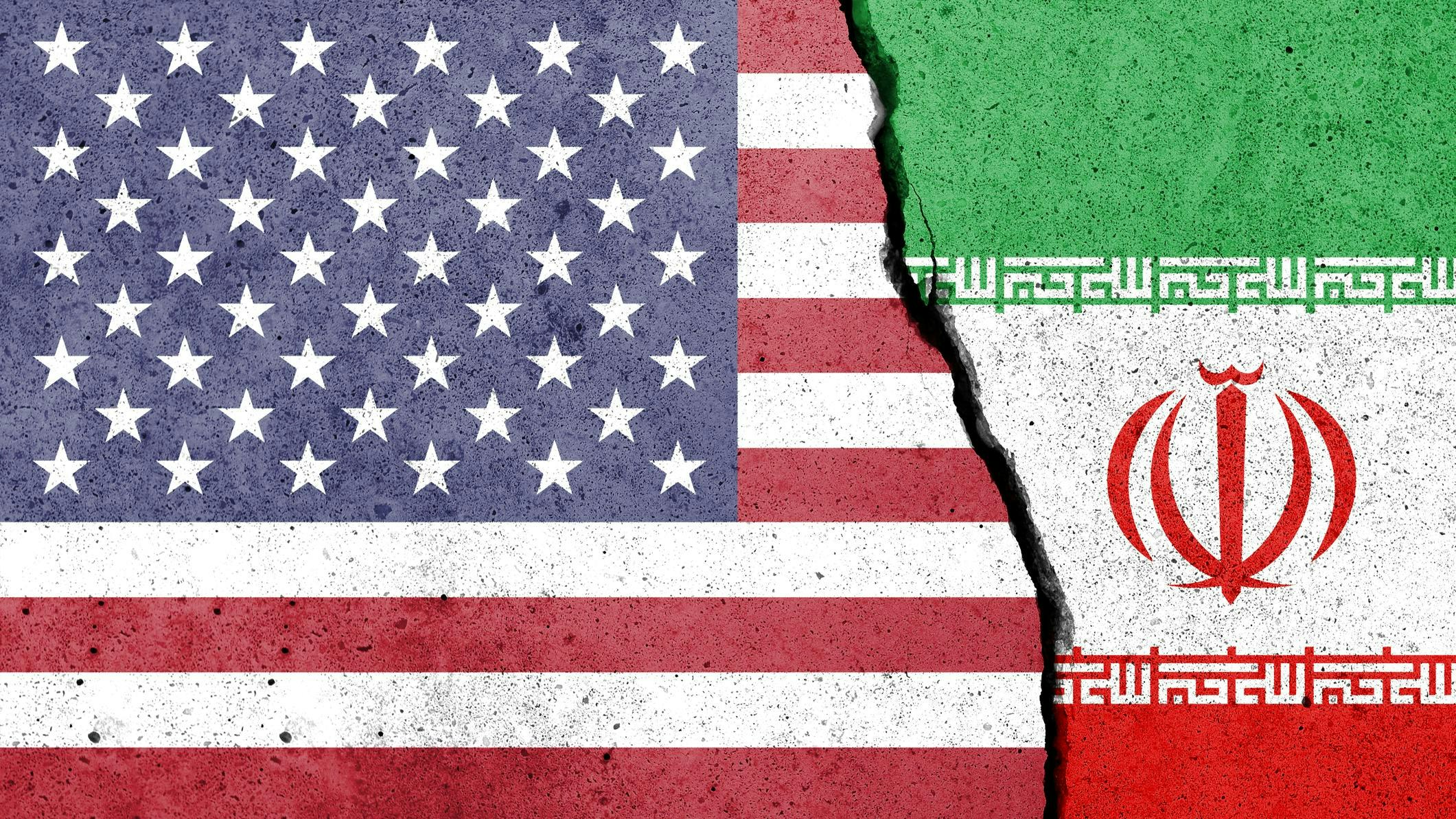 United States of America and Iran flags painted on the concrete wall. USA and Iran conflict