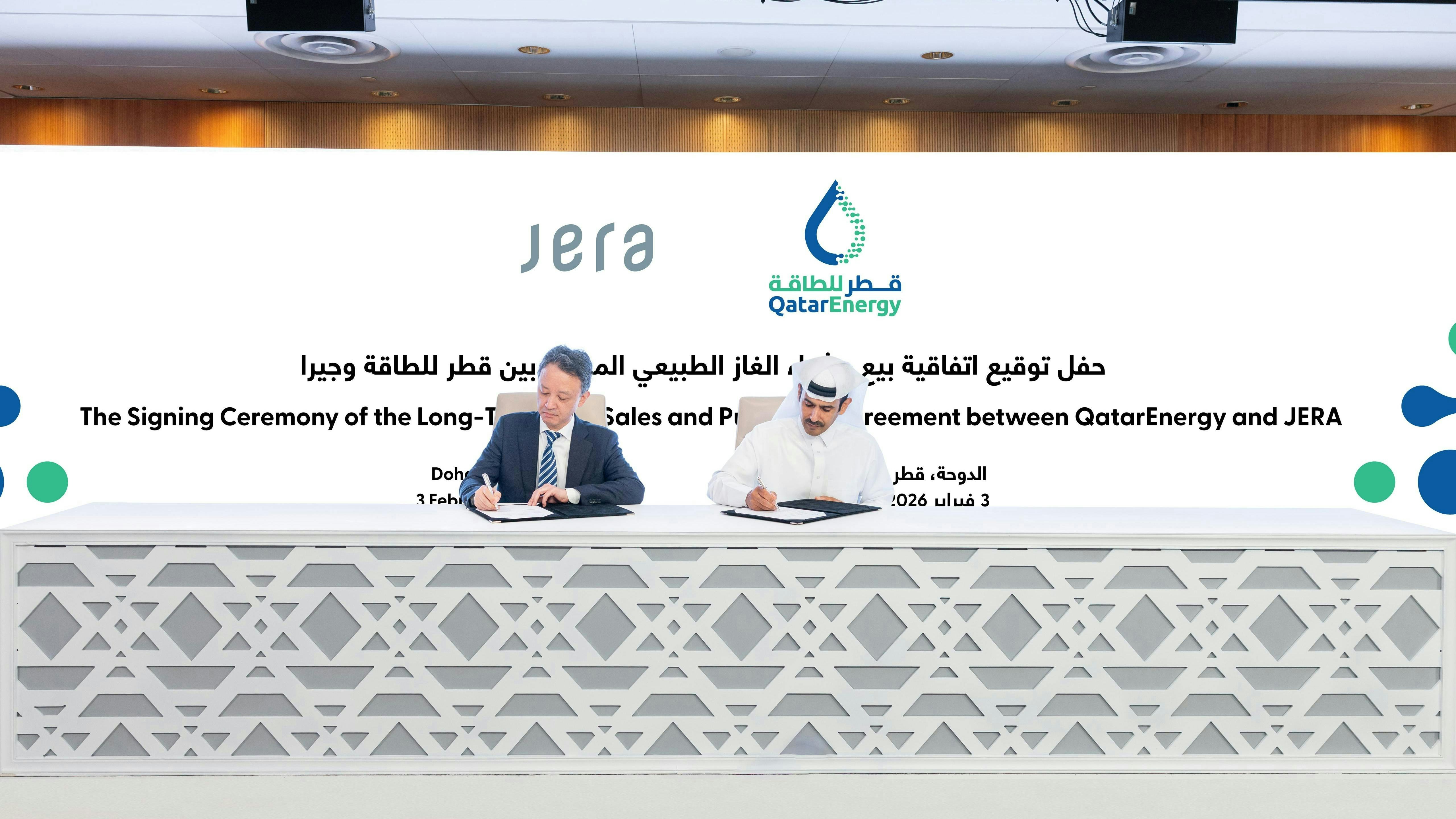 two men signing contracts at a table at a conference