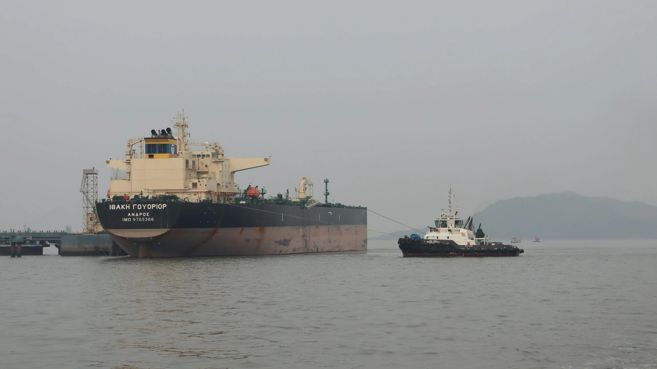 Russian oil tanker at dockyard with tugboat