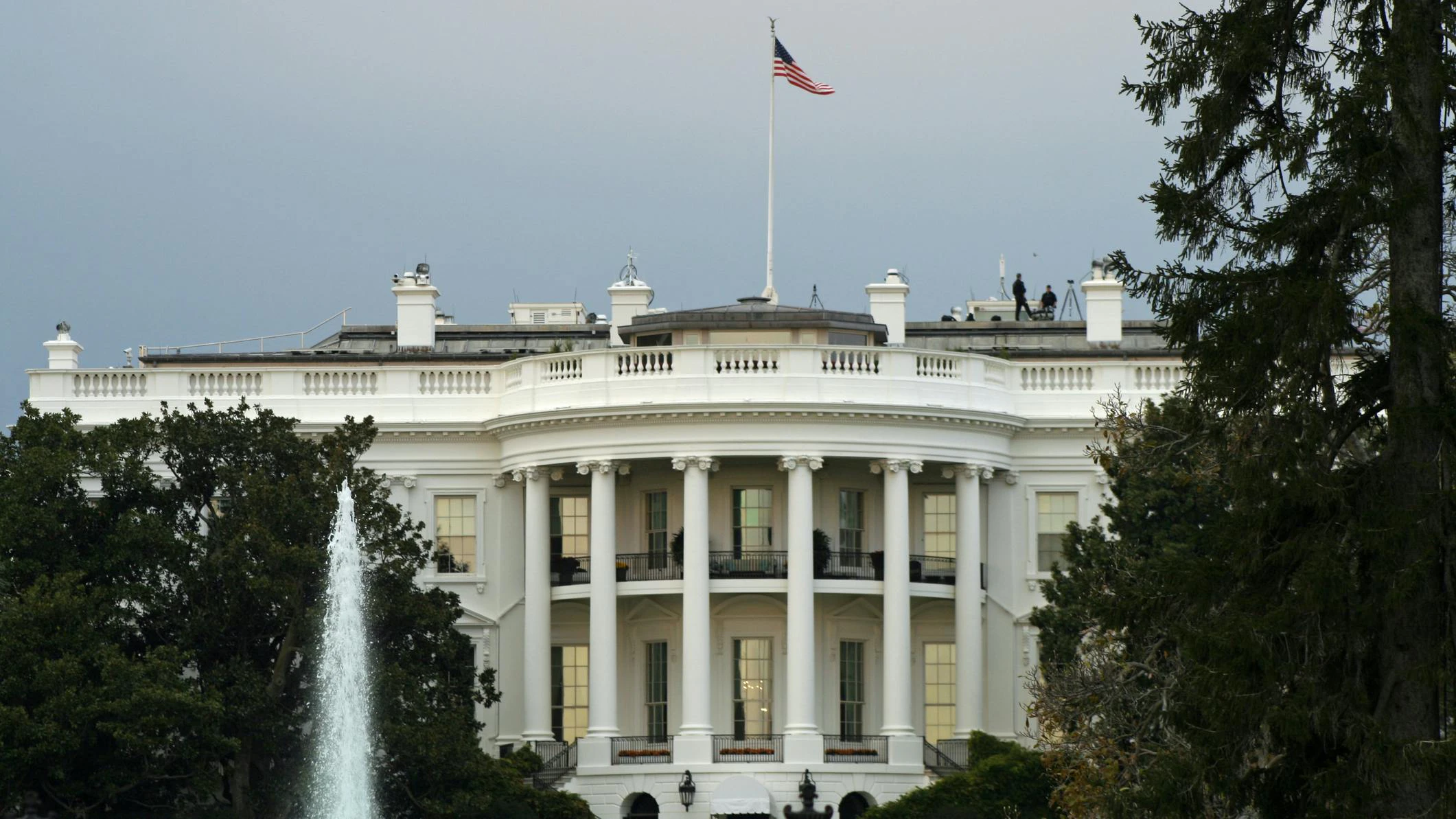 View of the US White House with water fountain and trees in foreground
