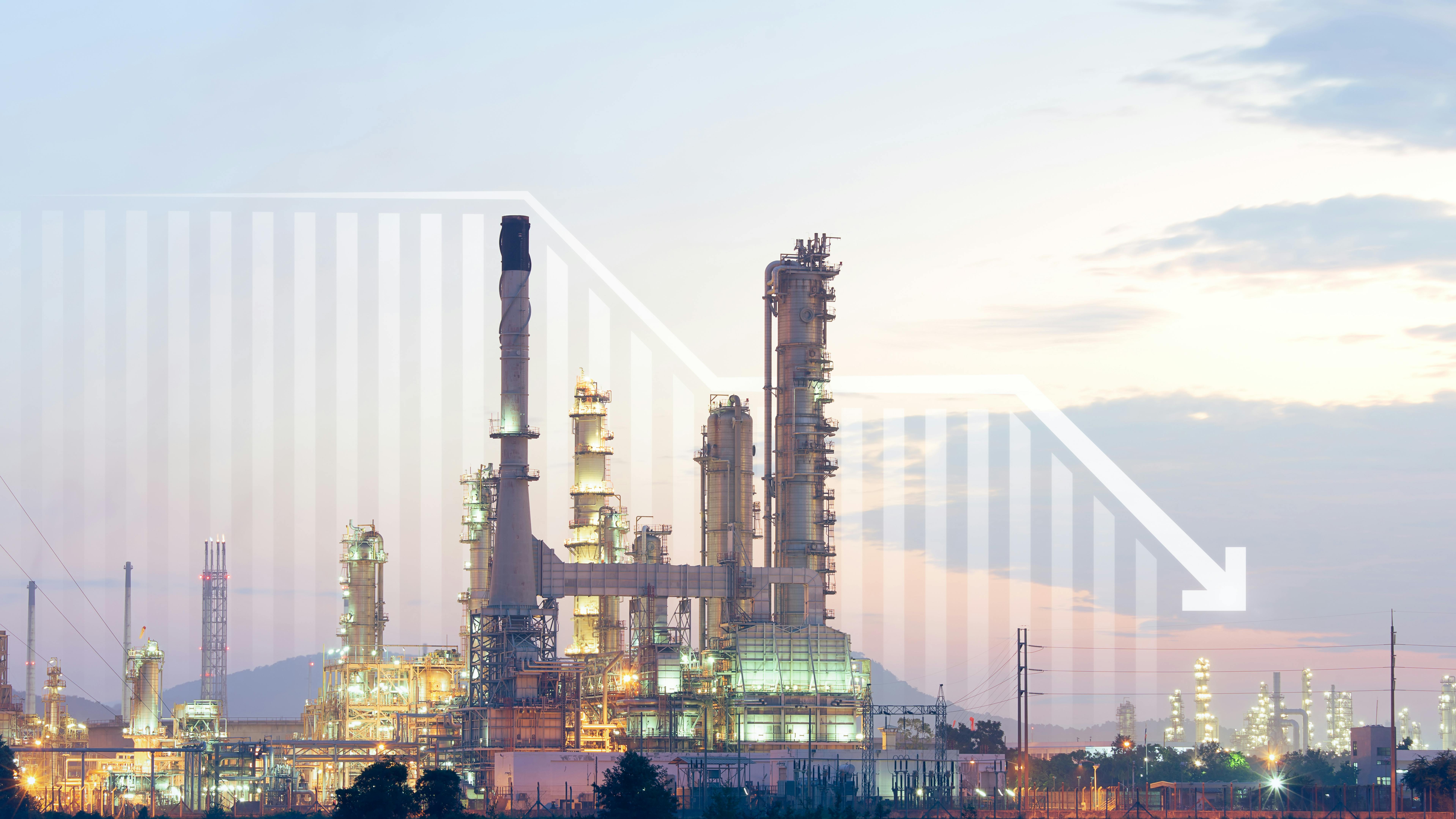 Oil gas refining-petrochemical complex with downward trending arrow on chart in background