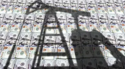 Shadow of oil and gas drilling equipment with picture of US currency in background