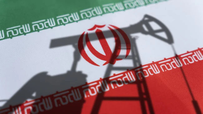 Shadow of oil and gas drilling equipment with Iran flag background