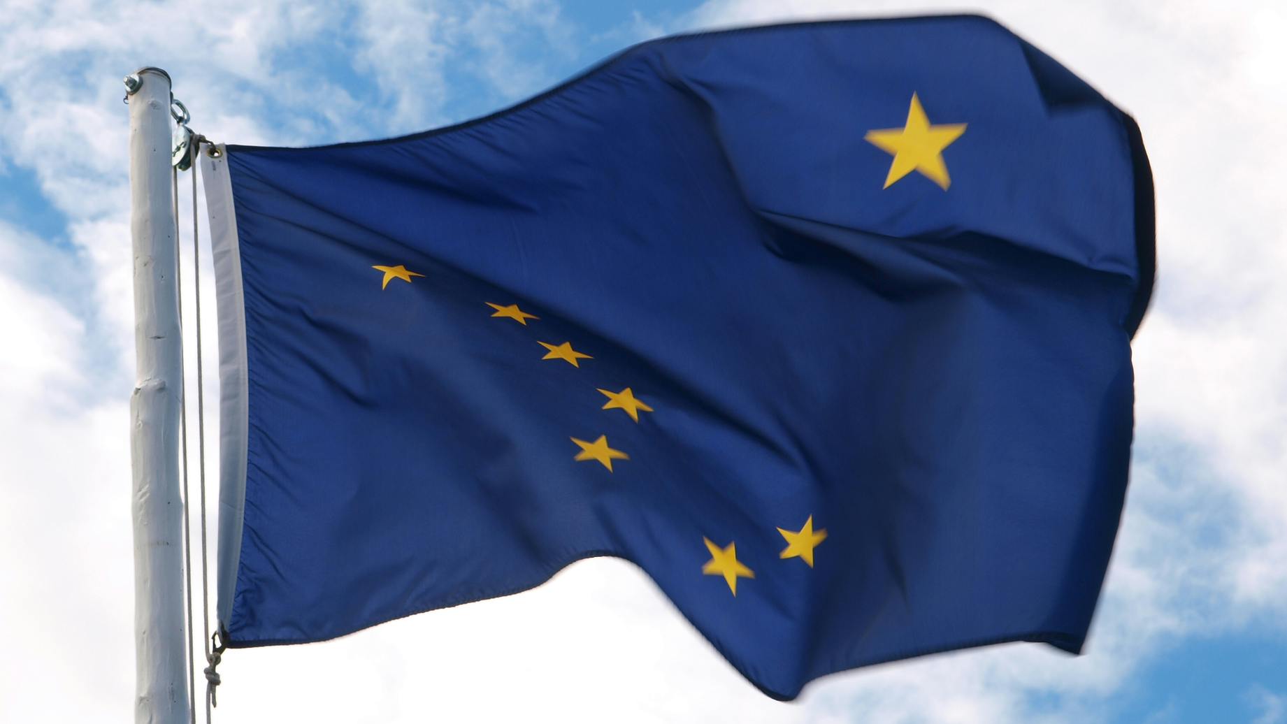Flag of Alaska in wind, yellow stars on blue background