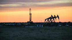 Oil and gas drilling rig, pump jack in front of sunset sky