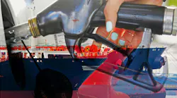 An oil tanker and a person refueling diesel at a petrol station