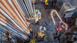 Offshore oil rig worker preparing equipment at wellhead platform.