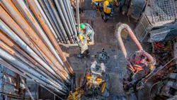 Offshore oil rig worker preparing equipment at wellhead platform.