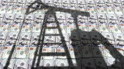 Shadow of oil pumpjack over stacks of US$100 bills