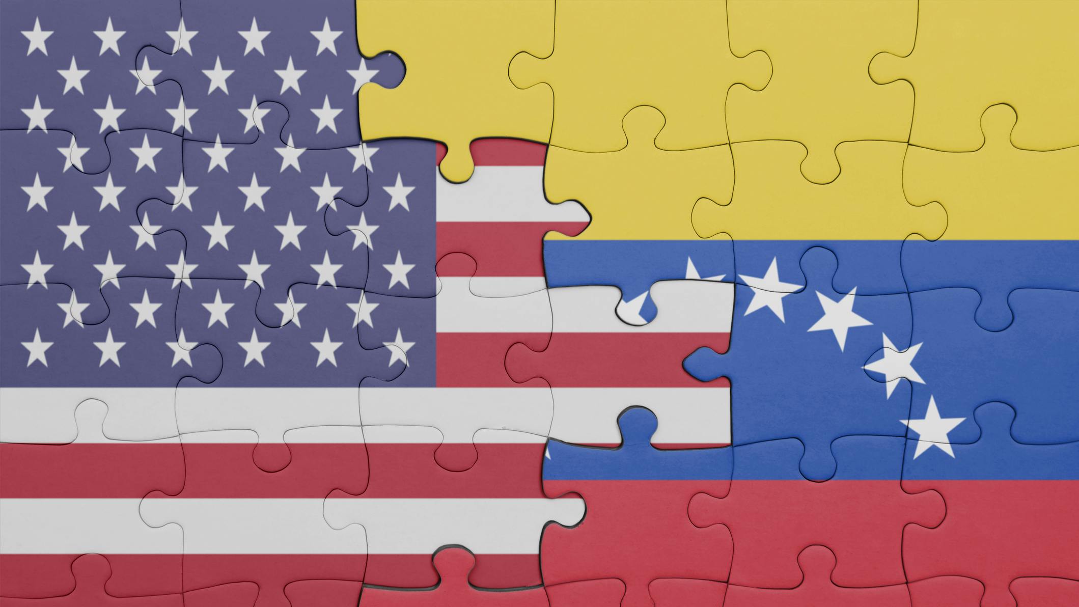 US and Venezuela flags composed through puzzle pieces.