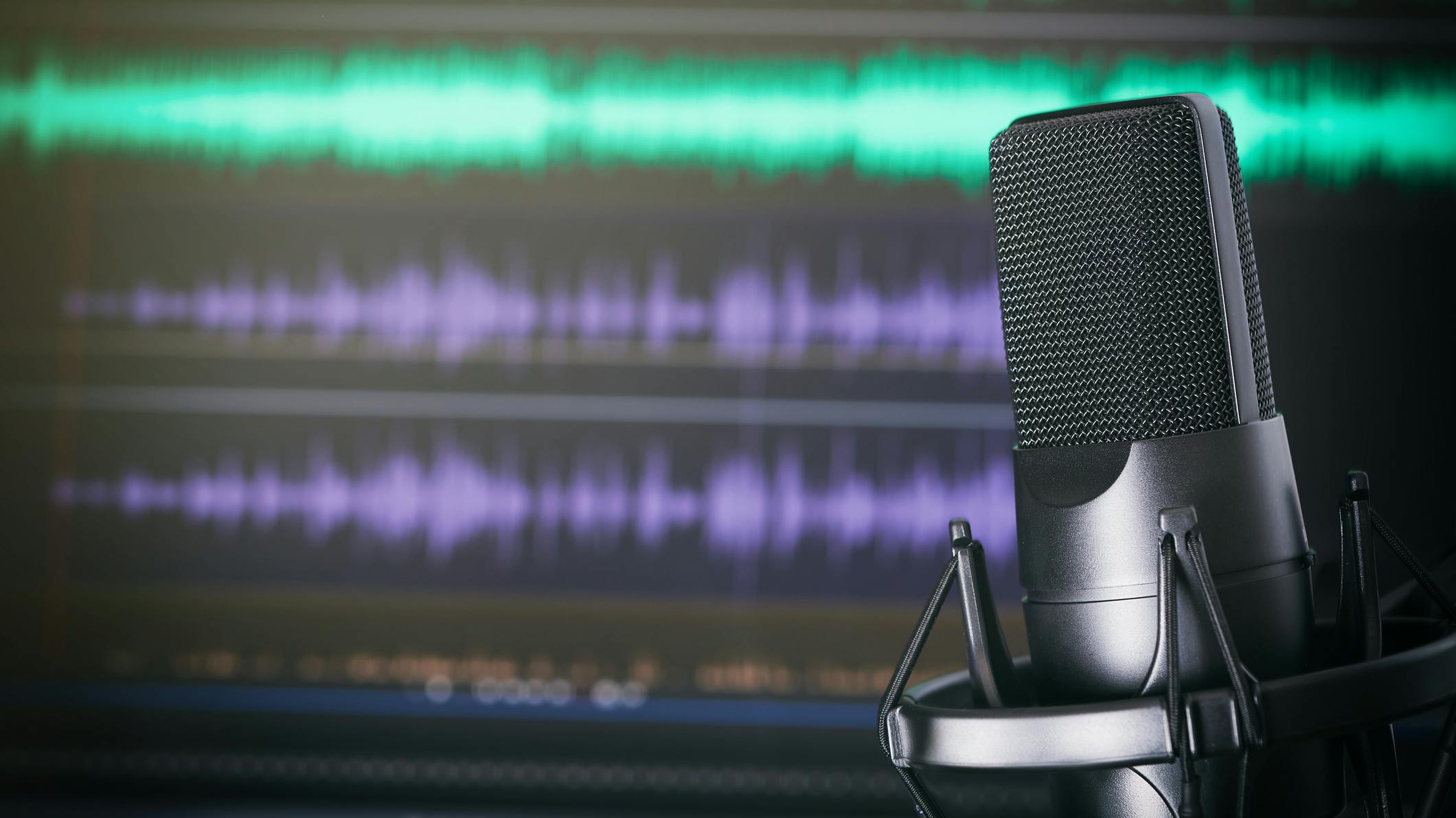 podcast mic in front of audio recording software screen