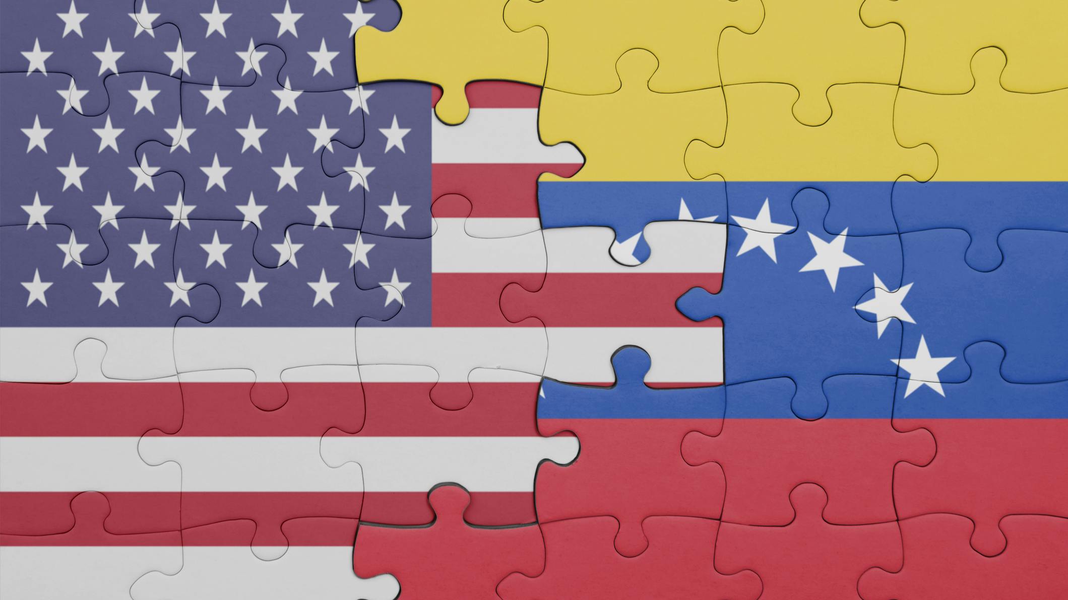 US and Venezuela flags depicted in puzzle pieces intertwined