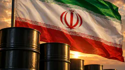 Flag of Iran billowing in wind over row of oil barrels.