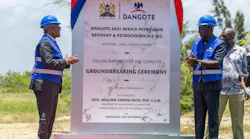 Large sign with red and blue ribbons draped along sides announcing future site of the Lamu refinery.