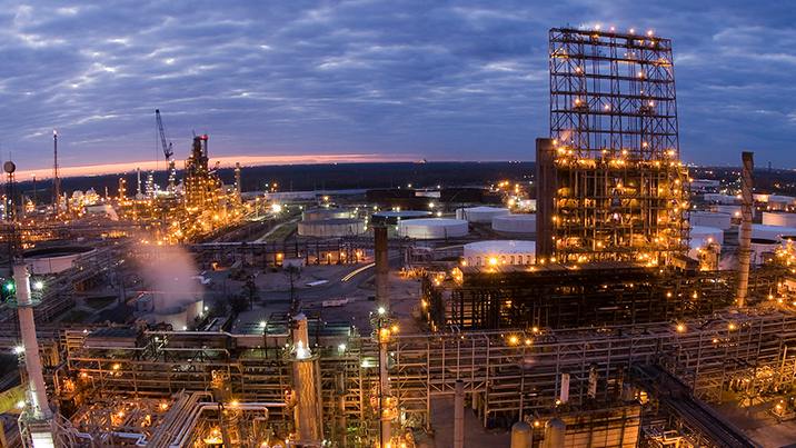 A nightime aerial view of Valero Refining New Orleans LLC&rsquo;s 340,000-b/d St. Charles refinery in Norco, La., showing illuminated refining installations beneath a cloudy bluish-pink twilight sky.