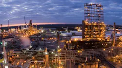 A nightime aerial view of Valero Refining New Orleans LLC’s 340,000-b/d St. Charles refinery in Norco, La., showing illuminated refining installations beneath a cloudy bluish-pink twilight sky.